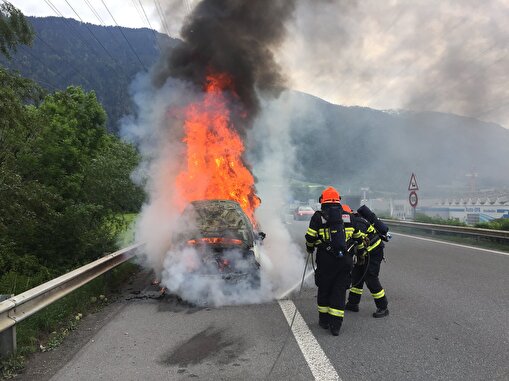 Die Feuerwehr beim Löschen des brennenden Fahrzeuges auf der Autobahn.