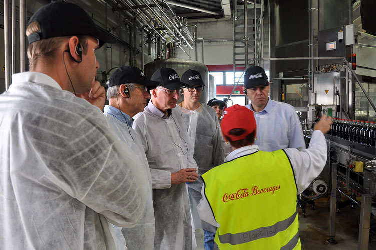 Churer Politprominenz auf der Tour durch die Coca-Cola-Fabrik in Dietlikon, wo ein Tropfen geheimnisvolles Elexier 1000 gefüllte 1-Liter-Flaschen des weltumspannenden Getränks ergibt.