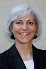 Gepflegte Dame mit grau meliertem, halblangem Haar.