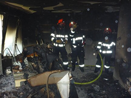 2 Feuerwehrleute stehen in der ausgebrannten Wohnung.