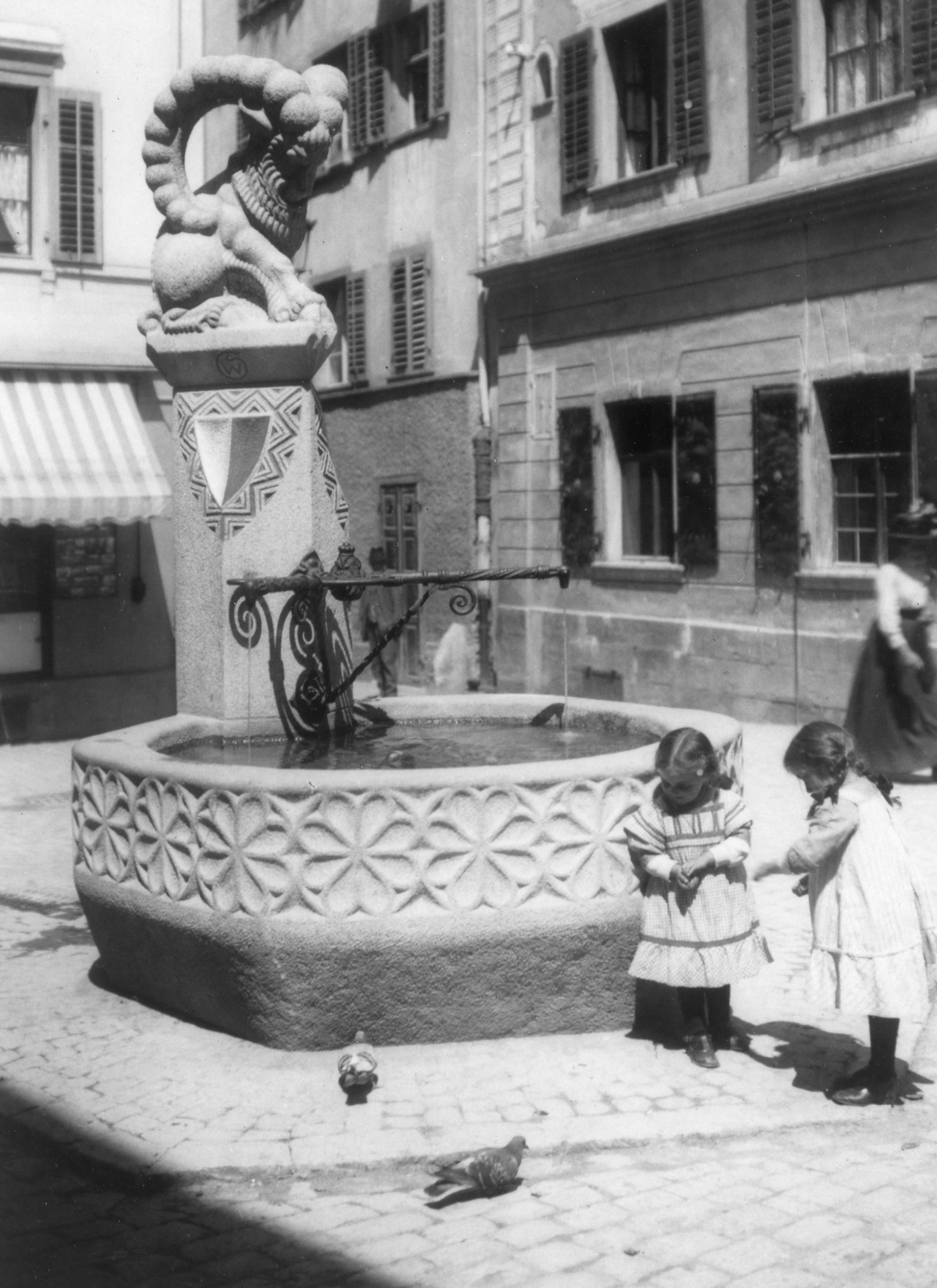 Fotografie zweier
Mädchen beim Majoranbrunnen. Der
Brunnen stammt von 1912 und wurde von
Bildhauer Wilhelm Schwerzmann erstellt.
(StadtAC, F 07.003.013, Fotograf unbekannt,
ca. 1913–1916).