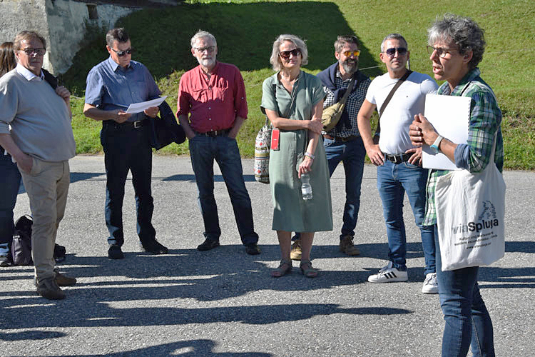 Sabina Wanner führt die Politprominenz aus Chur durch Splügen und erzählt von der Geschichte des Passdorfes.