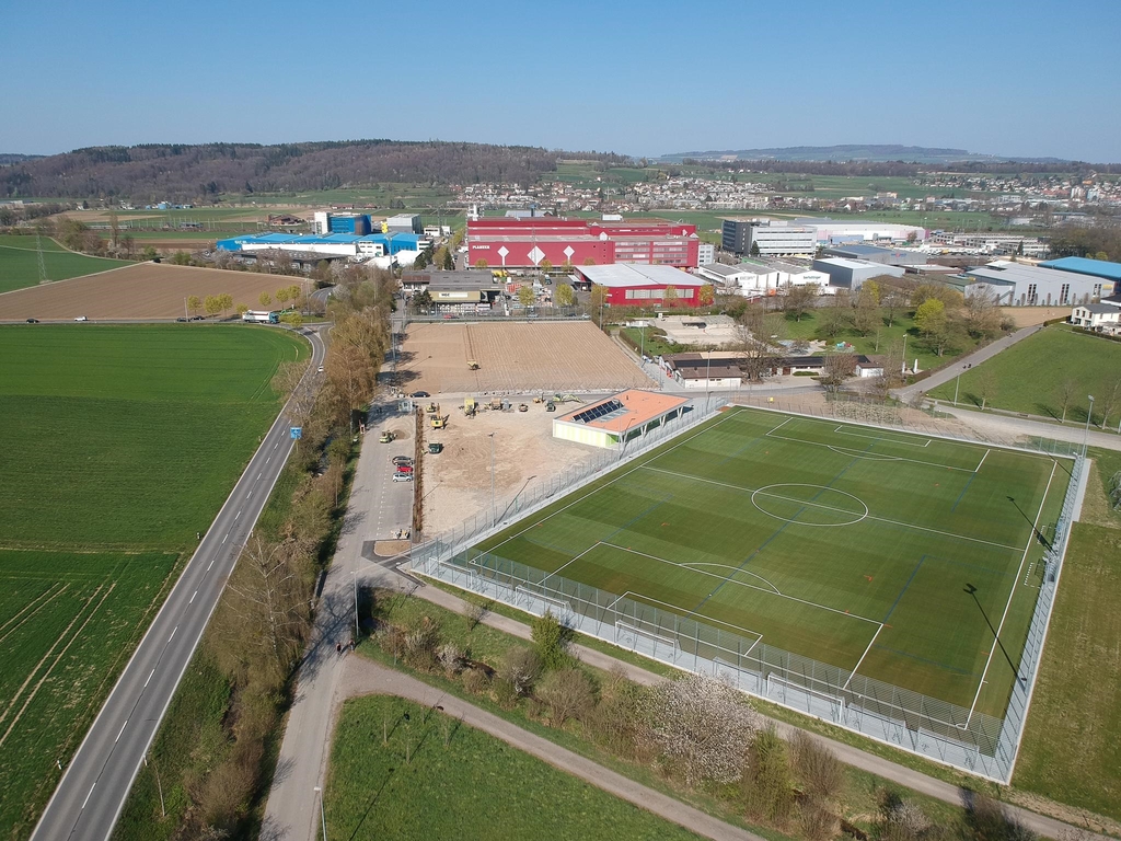 Nach dem Bau des Kunstrasenspielfeldes wurde mit der Sanierung des bestehenden Naturrasenspielfeldes begonnen. Diese Instandsetzung wird voraussichtlich bis im Mai 2020 dauern. Bis dann werden auch die Umgebungsarbeiten mit den Vorplätzen und dem neuen Schotterrasenparkplatz abgeschlossen sein.