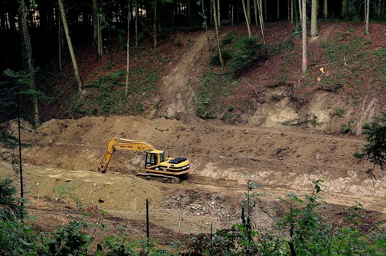 Grabarbeiten für die Umleitung des Hinterbachs, damit das bestehende Bachbett im Bereich des Rückhaltebeckens begradigt und in einen Betonkanal gefasst werden kann.