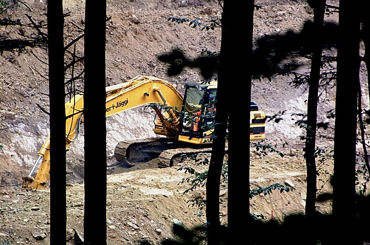 Der Bagger gräbt sich bei strömendem Regen ins Erdreich des abgeholzten Drachtenlochs.