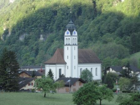 Die Pfarrkirche und ihre umliegenden Gebäude bestechen durch ihr interessantes und bis heute erhalten gebliebenes Ensemble. Dazu zählen nebst der Kirche (1777), das Beinhaus (1693), der Friedhof, das Missionskreuz (1651) und die Bruder Konrad Scheuber-Klause (16. Jahrhundert).

Das Innere der Pfarrkirche zeichnet sich durch seine klare Raumgestaltung aus, unter Verwendung von Wandpilastern mit reizvollen Stuckkapitellen im Rokokostil. Die Kirche besitzt dank ihrer wohlproportionierten Fenster eine hervorragende Lichtführung. Der spätbarocke Kirchenbau verfügt über prächtige Deckengemälde und gehört aufgrund seiner ausgewogenen Proportionen zu den hervorragendsten Bauten des Tiroler Baumeisters Johann Anton Singer.