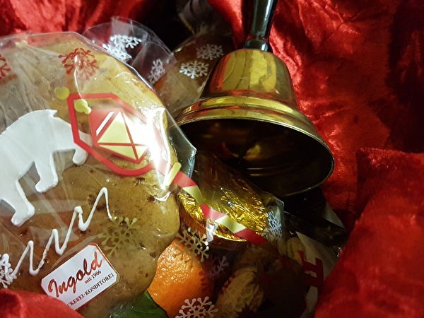 Lebkuchen und goldene Glocke auf rotem Samttuch