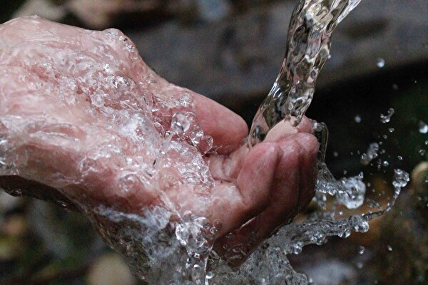 Hand unter einem Wasserhahnen