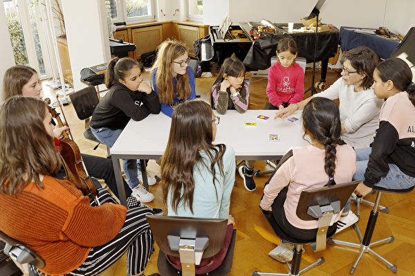 Schülerinnen und Schüler diverser Lehrpersonen behandeln spielerisch musiktheoretische Fragen zusammen mit Lehrperson Regula Anderes.