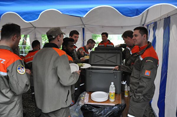 Die Küchenmannschaft schöpft das Mittagessen für die Zivilschützer