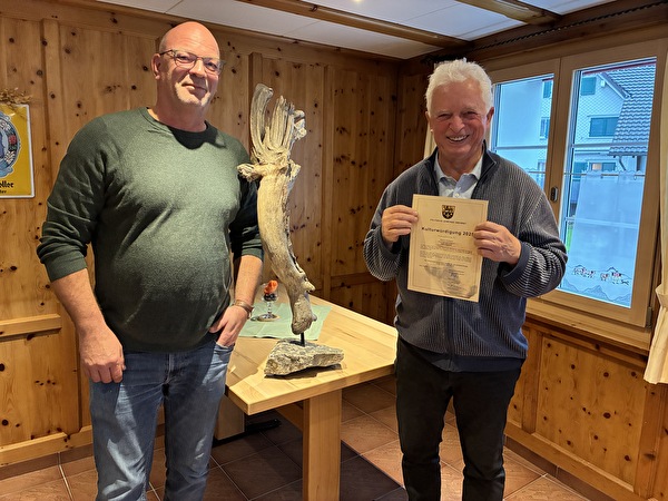 Gemeindepräsident Rolf Huber überreicht Alfons Ammann die Kulturwürdigung.