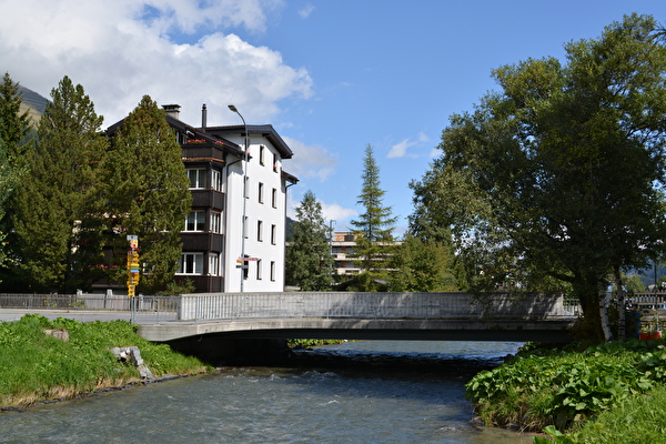 Das Landwasser fliesst eng an Gebäuden im Platz vorbei