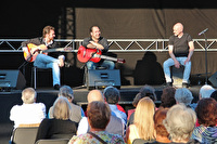 Rafael Cortes mit Gitarre und zwei Bandmitgliedern