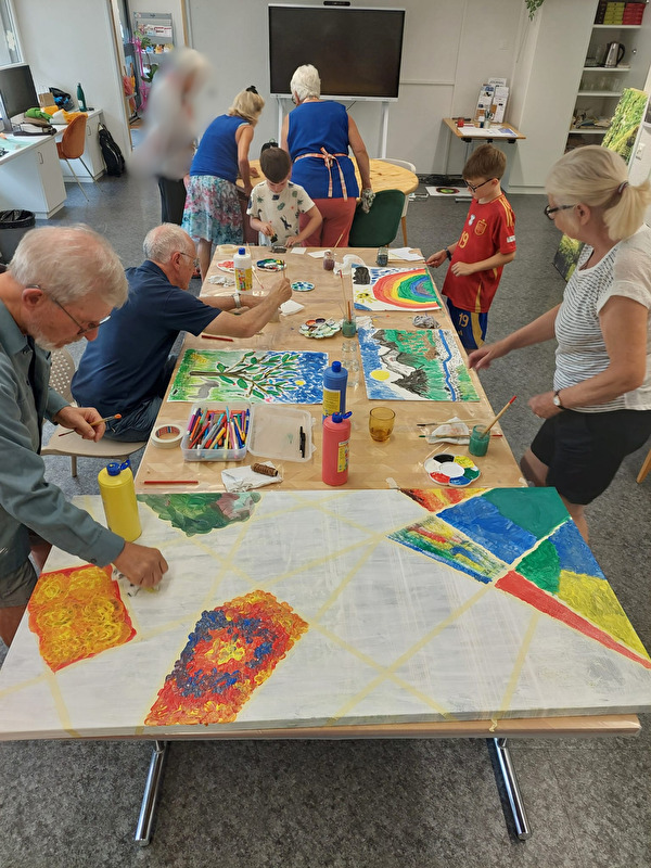 Impression vom ersten Workshop Gemeinschaftsbild gestalten. Verschiedene Personen malen Bilder, die dereinst das Quartierzentrum Blickensdorf schmücken sollen.