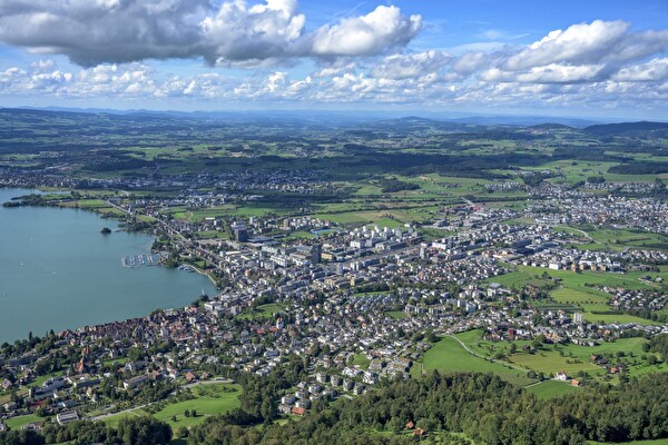 Luftansicht von Zug, Baar, Cham und Steinhausen mit der Lorzenebene in der Mitte.