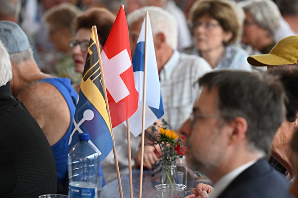 Besucherinnen und Besucher der 1. August-Feier und drei Flaggen: Baar, Schweiz, Zug
