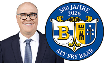 Bundesrat Martin Pfister und das Logo der Feier 500 Jahre alt fry Baar