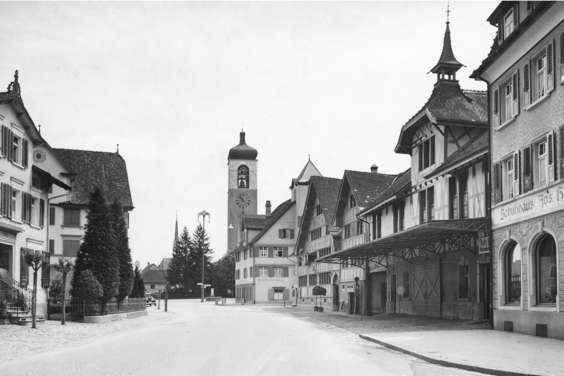 St. Gallerstrasse mit Blick in Richtung Kirchplatz. Auf der rechten Strassenseite das Gasthaus Sonne, der Schwarze Adler mit dem markanten Turm und zentral der Turm der Anderaskirche.