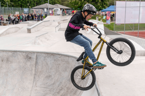 Ein Knabe fährt mit dem BMX im Skatepark