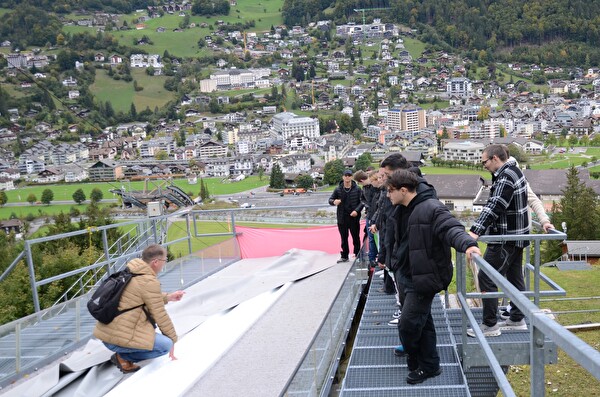 Eine Gruppe junger Menschen auf einer Skisprungschanze.