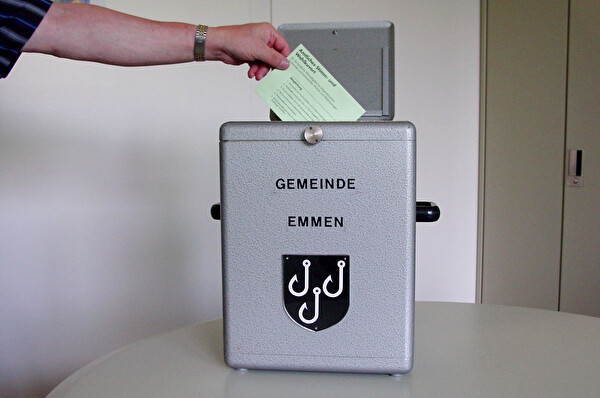 Wahlzettel wird in Urne gelegt.