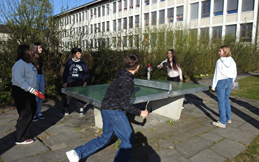 Junge Menschen bei einem Pingpong-Tisch.