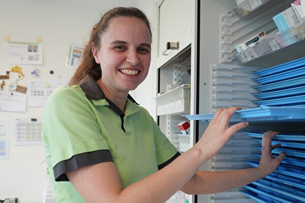 Eine Frau vor einem Regal.