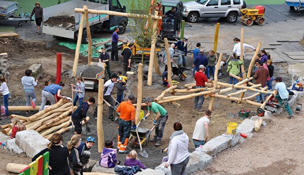 Menschen auf einer Spielplatzbaustelle.