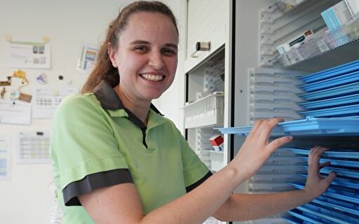 Eine Frau vor einem Regal.