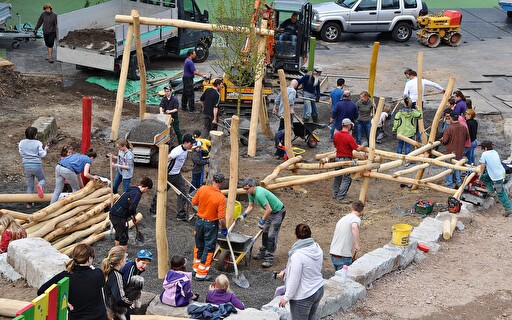 Menschen auf einer Spielplatzbaustelle.