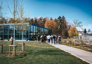 Menschen spazieren durch ein Freibad.
