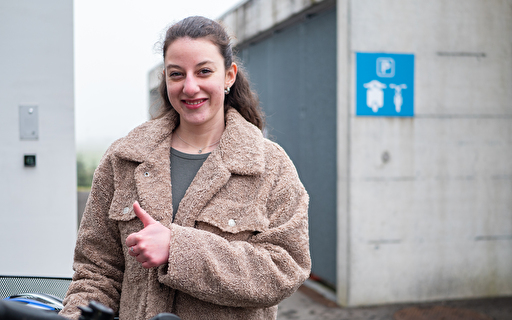 Eine Junge Frau bei einem Veloparkplatz