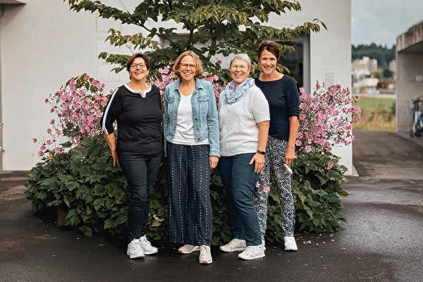Vier Frauen vor einer Staude.