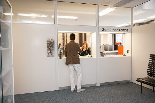 Kunde besucht Schalter der Gemeindekanzlei.