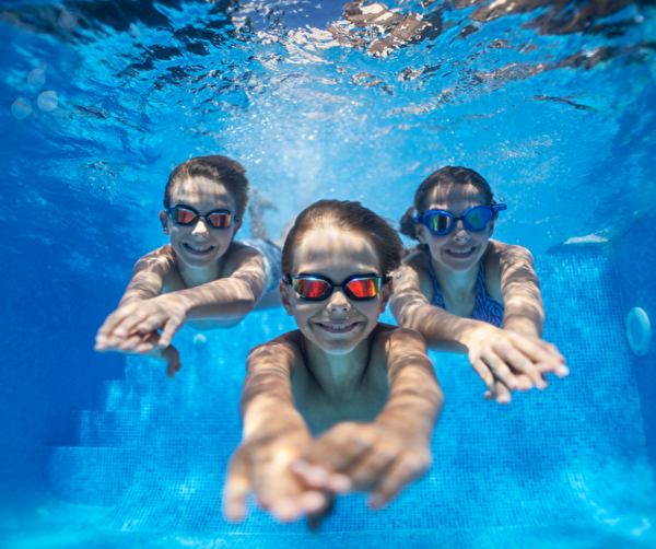 Schwimmende Kinder unter Wasser