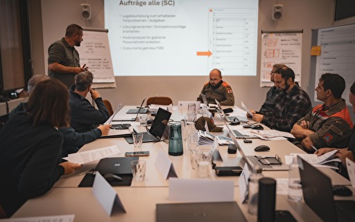 Beschäftigte Gruppe an grossem Tisch