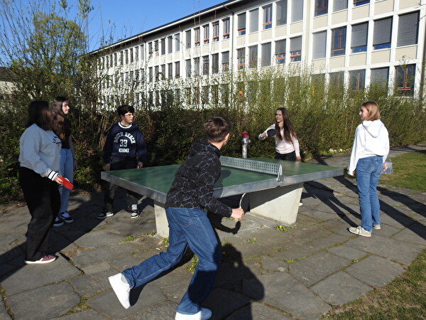 Junge Menschen bei einem Pingpong-Tisch.