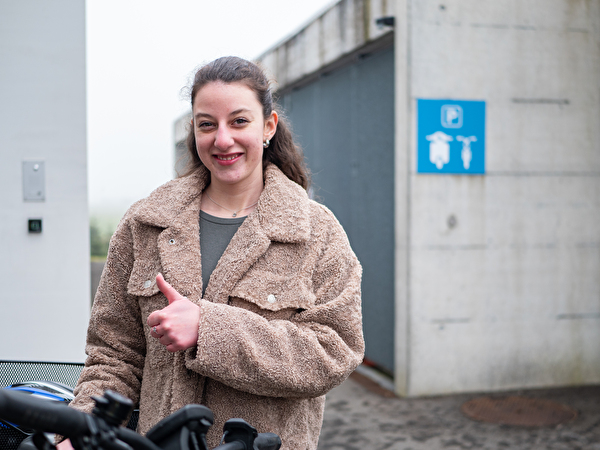 Eine Junge Frau bei einem Veloparkplatz