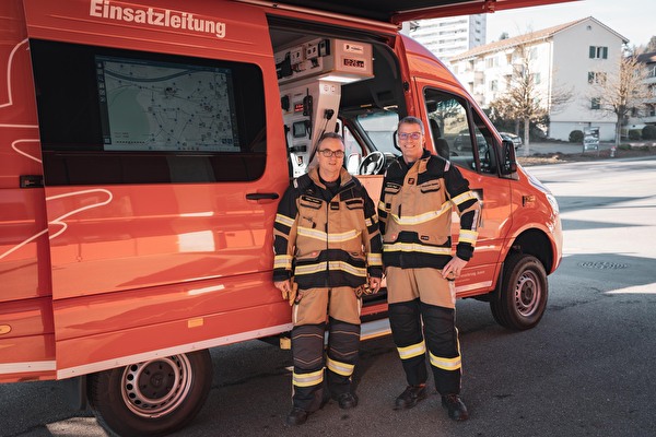 Zwei Männer vor einem Auto.