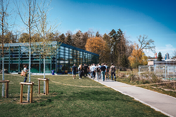 Menschen spazieren durch ein Freibad.