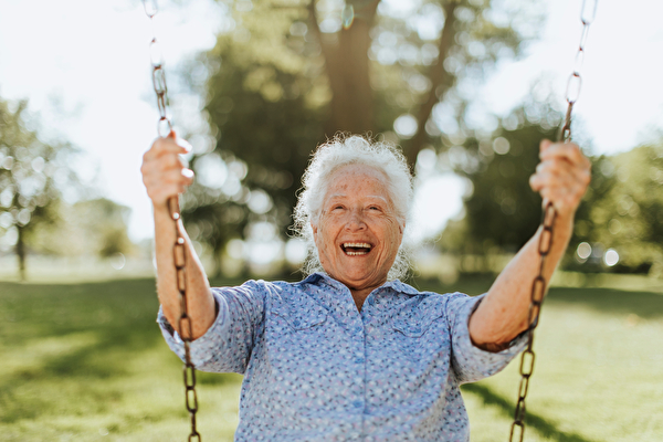 Beschwingte Seniorin auf Schaukel