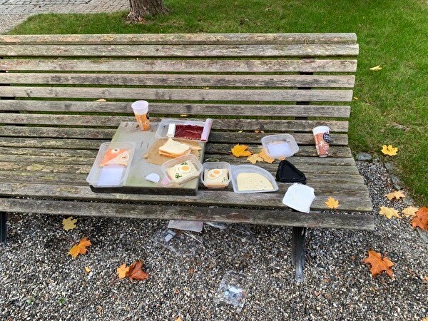 Offene Lebensmittel und Getränke auf einem Bänkli auf dem Friedhof Scherzingen