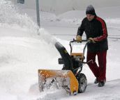 Bild eines Mannes welcher Schnee fräst