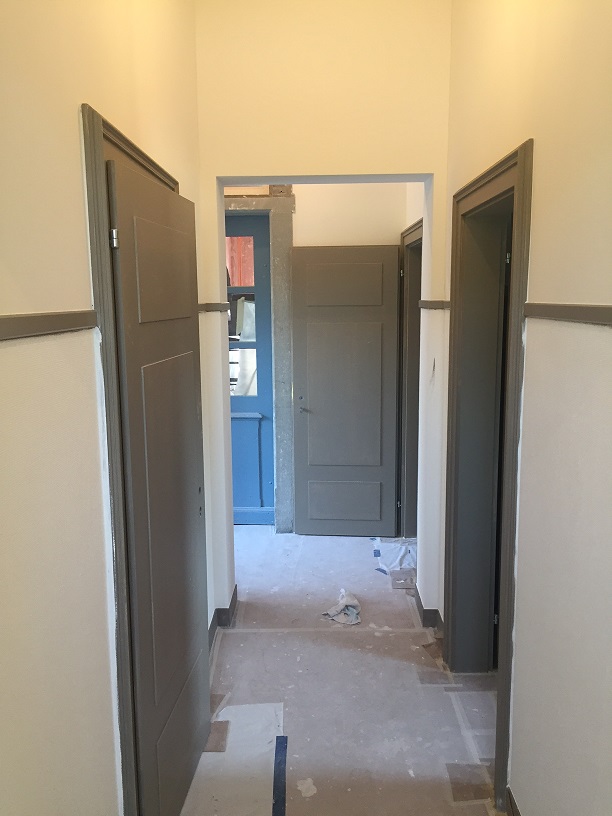 Die verputzten Wände im Flur vor den WC-Anlagen und zum Lift sind fertig gestrichen und die Türen sind grundiert.