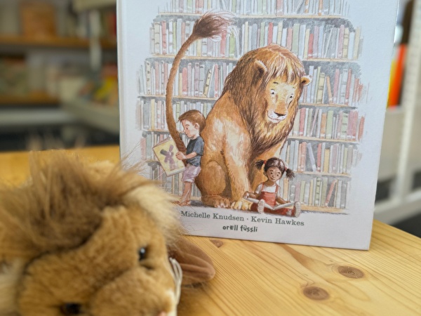Buchcover Löwe in der Bibliothek und Plüschlöwe