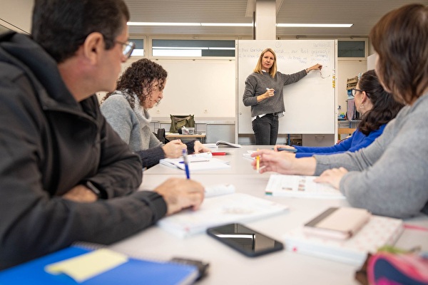 Lehrerin erklärt erwachsenen Schülern etwas