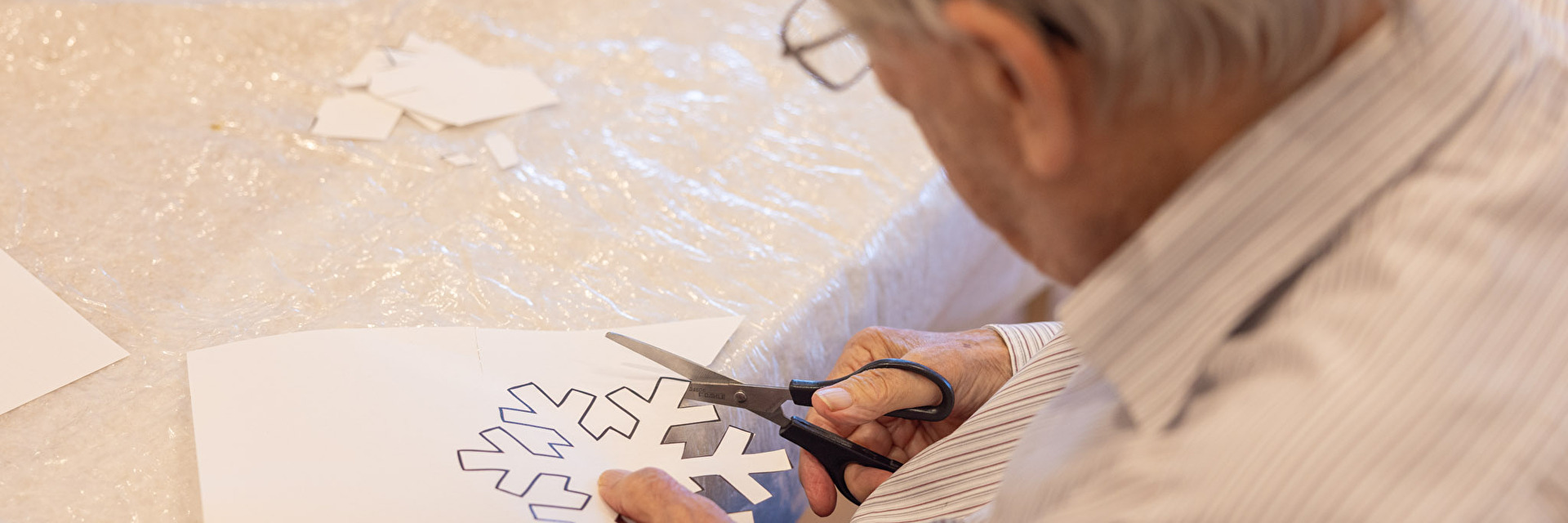 Mann schneidet Schneeflocke aus