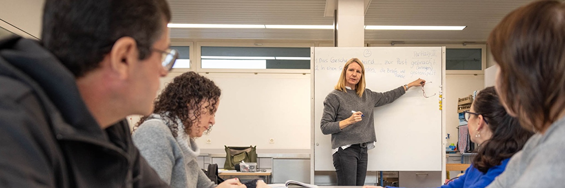 Lehrerin erklärt erwachsenen Schülern etwas