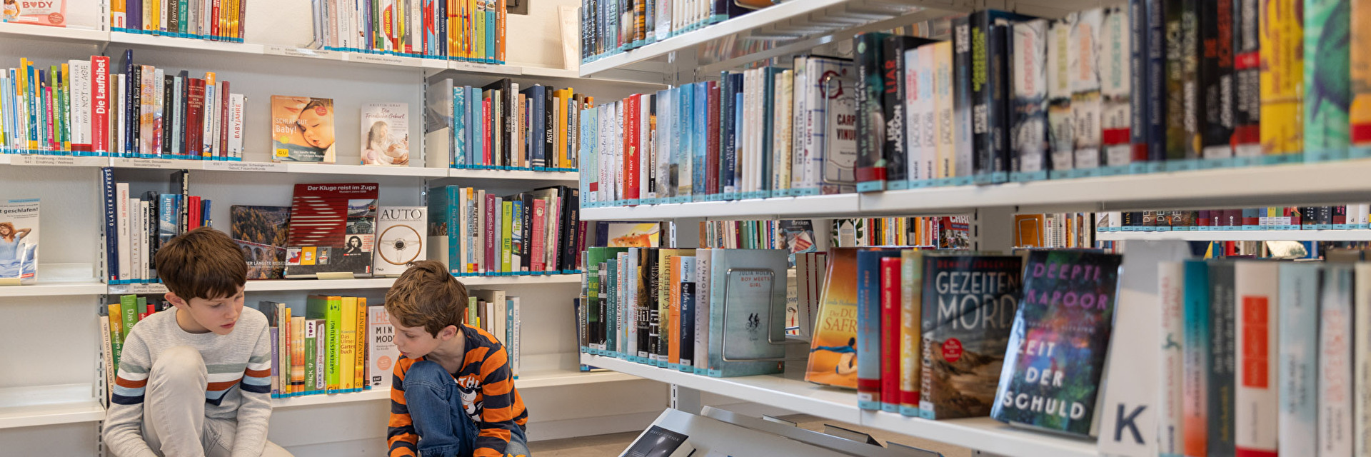 Zwei Buben schauen Bücher an