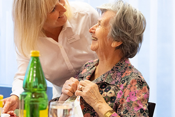 Kellnerin bedient ältere Frau
